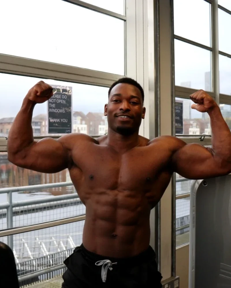 James posing in the gym, flexing his biceps