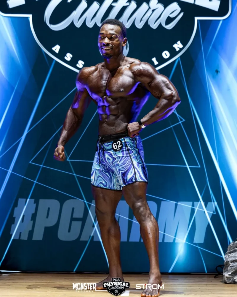 James posing on stage during a bodybuilding competition